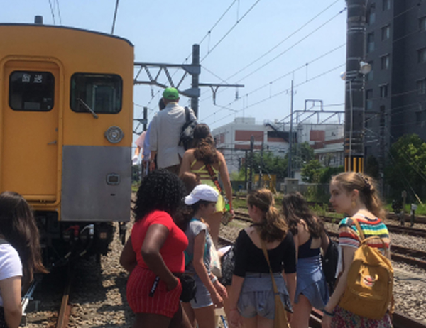 日本の学生と外国人留学生が街を歩きながら交流している様子。観光や地域探訪を楽しんでいる風景