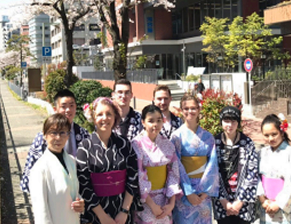 日本人学生と海外からの留学生が横浜の街で笑顔で集合写真を撮っている様子