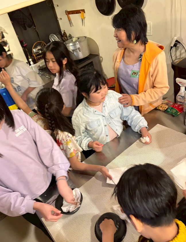 大人とこどもたちが一緒にテーブルを囲んで作業をしている様子